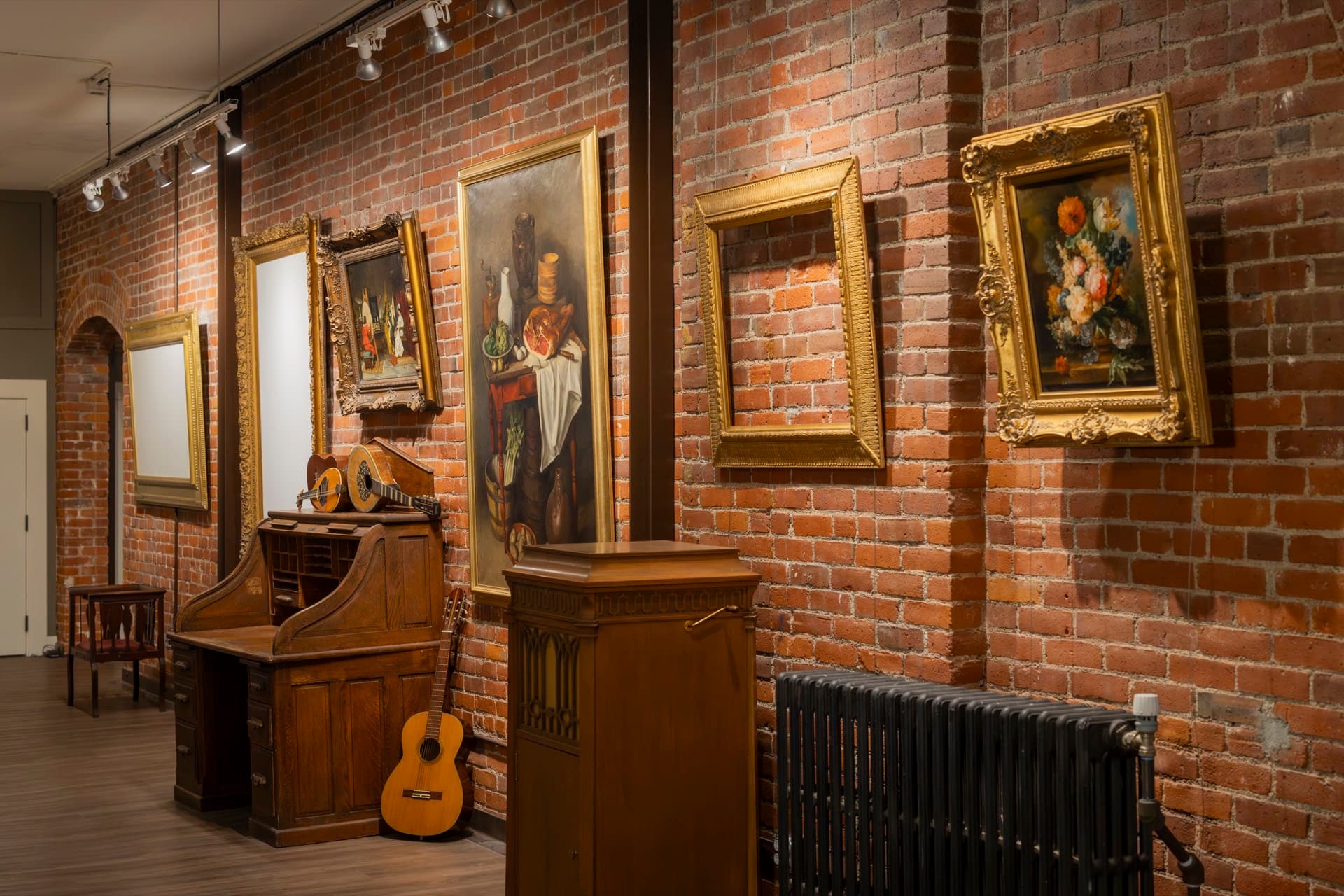 Gilt-framed paintings hung on the brick gallery walls of the Occidental Fine Arts Center