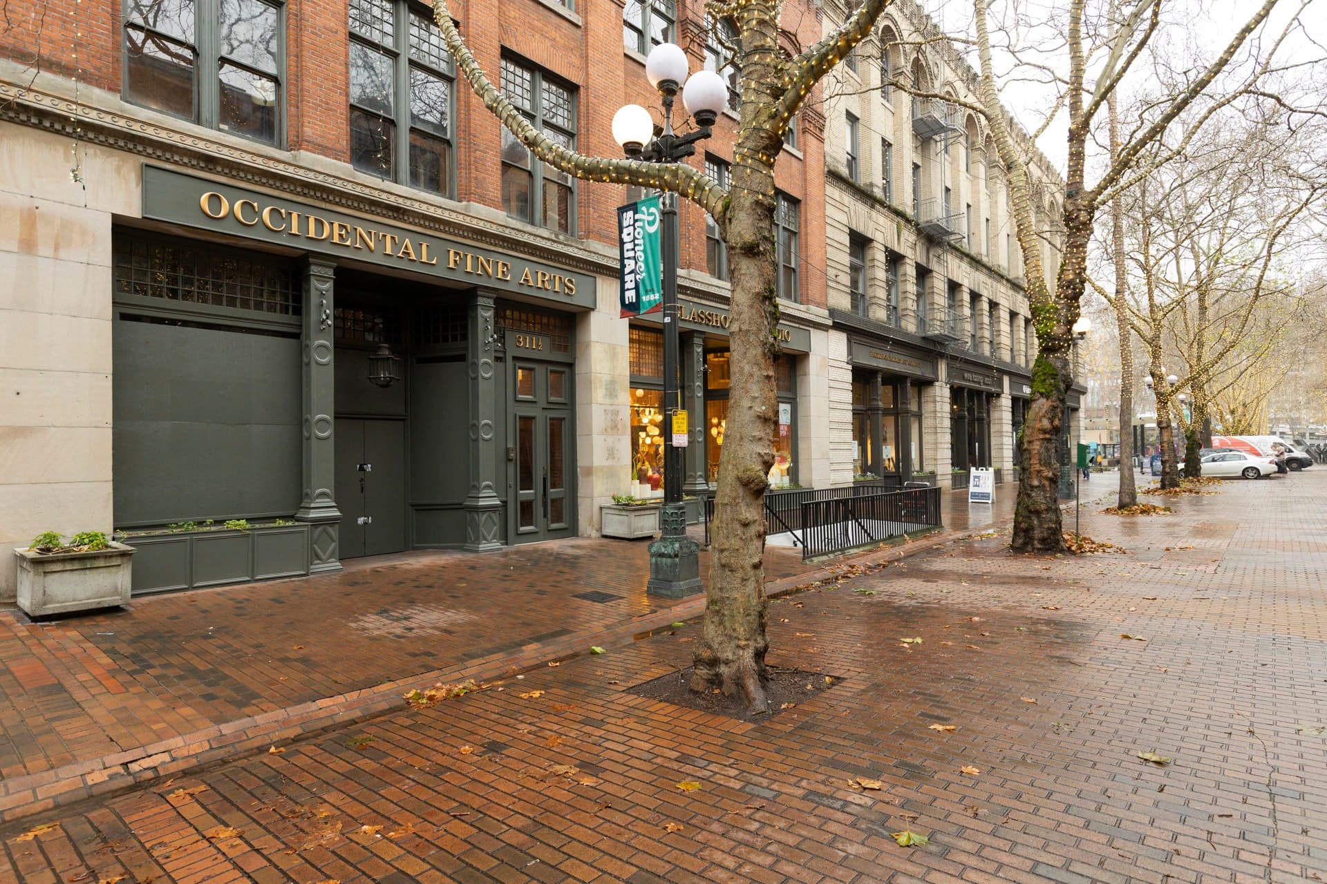 The Occidental Fine Arts Center storefront on a brick street in Pioneer Square